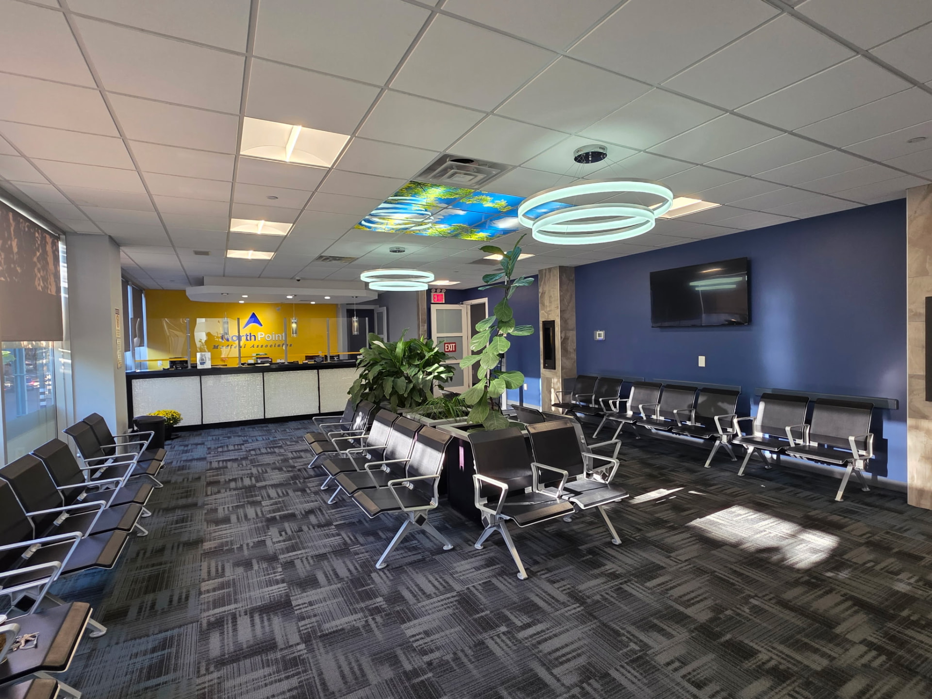 The NorthPoint Medical Associates reception desk and patient waiting area, with the clinic's name on a bright yellow wall